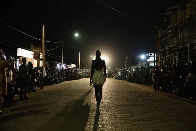 Residents lineup to watch Models participate in the third edition of Ouaga Fashion Week in Ouagadougou, Burkina Faso, Saturday, May 14, 2022. (Photo by Sophie Garcia/AP Photo)