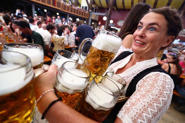 A waitress carries beers in the Paulaner tent on the opening day of the 189th edition of the traditional Oktoberfest beer and amusement festival in the Bavarian capital Munich, Germany, 21 September 2024. According to its organizers, the Oktoberfest has grown into the world's largest folk festival, drawing around six million visitors annually. The festival's 189th edition will run from 21 September to 06 October 2024 on the Theresienwiese. (Photo by Anna Szilágyi/EPA/EFE)