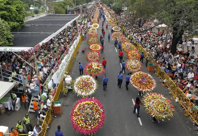 Flower growers known as “silleteros” carry their flower arrangements during the annual flower parade in Medellin, Colombia, August 9, 2015. (Photo by Fredy Builes/Reuters)