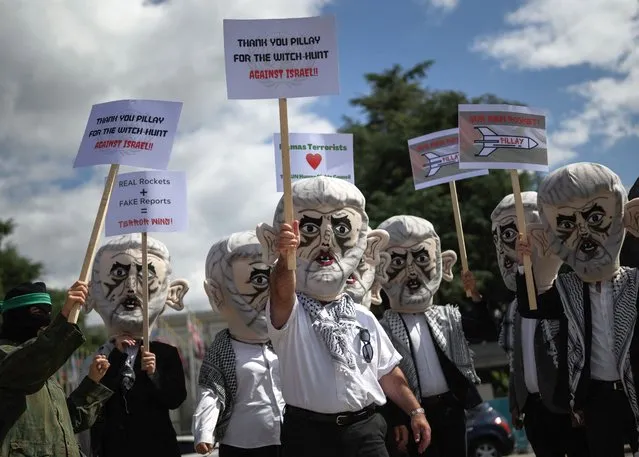 Israel's Defense Force reservists, wearing mask depicting Yahya Sinwar the Hamas chief in the Gaza Strip and holding Palestinian flags, protest outside the United Nations Offices in Geneva on June 7, 2022. The demonstration, organized by Israeli NOG Shurat HaDin, demands Human Right Council upcoming Pillay Report labeling Israel an “apartheid state” to be cancelled. (Photo by Fabrice Coffrini/AFP Photo)