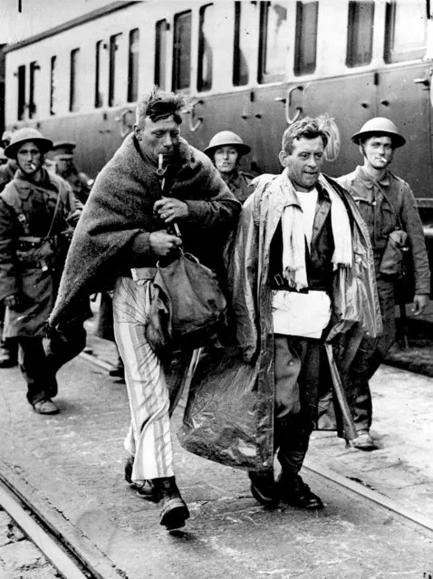 A group of British soldiers arrive in England after the evacuation of Flanders, France, on June 6, 1940 in World War II. The British soldier at left wears his pajamas instead of his uniform and a blanket around his shoulders for warmth and smokes a pipe.  In Operation Dynamo, over three-hundred thousand French, British and Belgian troops escaped the German invasion from the beaches near Dunkirk, France. (Photo by AP Photo)