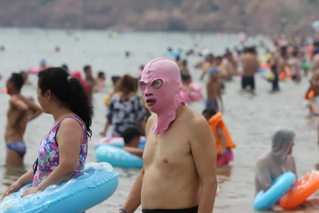 A man wears a facekini mask in a seaside resort in Qingdao, China on July 22, 2017. (Photo by Reuters/China Stringer Network)