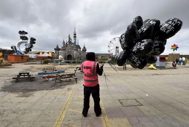 A performer holds a bunch of balloons at “Dismaland”, a theme park-styled art  installation by British artist Banksy, at Weston-Super-Mare in southwest England, Britain, August 20, 2015. (Photo by Toby Melville/Reuters)