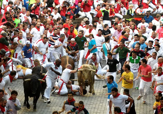 Runners fall in front of Fuente Ymbro fighting bulls near the entrance to the bullring, during the first running of the bulls at the San Fermin festival in Pamplona, northern Spain, July 7, 2016. (Photo by Eloy Alonso/Reuters)