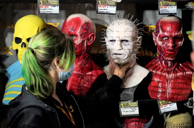 Jenn Brown of CFX (Composite Effects) adjusts a silicon mask based on Pinhead from the movie franchise “Hellraiser” in their stall during Preview Night at the 2022 Comic-Con International at the San Diego Convention Center, Wednesday, July 20, 2022, in San Diego. (Photo by Chris Pizzello/AP Photo)