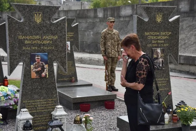 A woman reacts as she visits the tomb of her relative, a Ukrainian serviceman who was killed in a fight against Russian-backed separatists in the country's eastern regions, on The Day of Ukrainian Statehood in Lviv, Ukraine on July 28, 2022. (Photo by Pavlo Palamarchuk/Reuters)