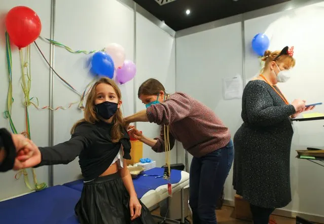 Eleven-year-old Chiara receives a dose of the Pfizer-BioNTech vaccine for children against the coronavirus disease (COVID-19) during a vaccination event for children at the Lanxess Arena in Cologne, Germany, December 18, 2021. (Photo by Thilo Schmuelgen/Reuters)