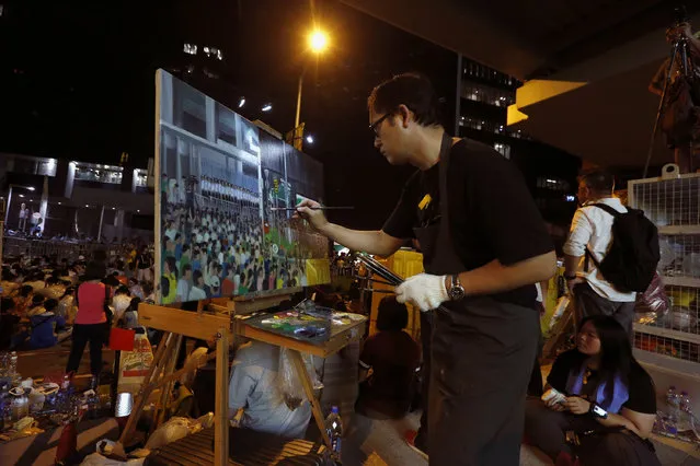 A man paints the scene of protesters and riot police during a rally attended by thousands in front of the government headquarters in Hong Kong September 27, 2014. (Photo by Bobby Yip/Reuters)