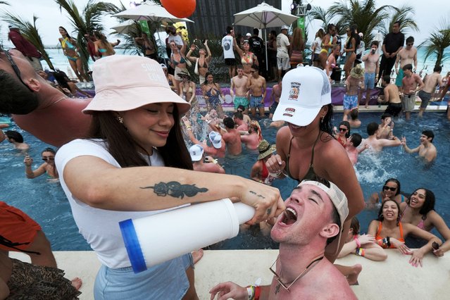 A man drinks from a bottle in a pool party at a beach club during the spring break, in Cancun, Mexico, on March 10, 2025. (Photo by Paola Chiomante/Reuters)