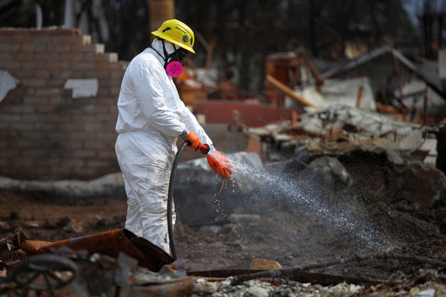 A U.S. Army Corps of Engineer contractor washes off his hand during debris removal following the Palisades Fire in the Pacific Palisades, Los Angeles, California, on March 17, 2025. (Photo by Daniel Cole/Reuters)