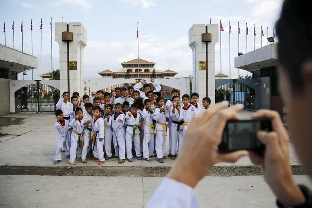 A group of taekwondo students pose for a picture in front of the parliament during a nationwide strike, called by the opposition parties against the proposed constitution in Kathmandu, Nepal September 20, 2015. (Photo by Navesh Chitrakar/Reuters)