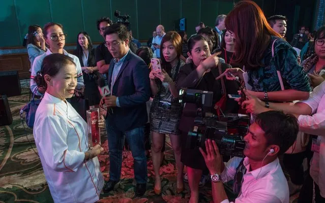 Jay Fai (L), the cook and owner of a street food eatery in Bangkok, speaks to reporters after her street- side eatery was recognised with a one- star Michelin guide mark at a hotel in Bangkok on December 6, 2017. In a city famous for street food, a roadside restaurant with plastic tables and simple but sumptuous fare has earned one of the dining scene' s highest honors: a Michelin star. Jay Fai' s was the only streetside establishment listed in Michelin' s first- ever Bangkok guide released on December 6 that touted the Thai capital' s culinary scene as “diverse as it is surprising”. (Photo by Roberto Schmidt/AFP Photo)