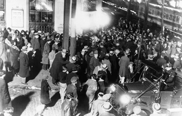 The scene outside a bank in the Bronx in New York City, USA around December 9, 1930 where three million dollars in cash were delivered to stem a mad rush made by investors after news was circulated that the bank was in difficulties. Clerks were pushed from other branches to help pay out, and mounted and foot police were present in great force to control the mobs. There is a police car in the foreground. (Photo by AP Photo)
