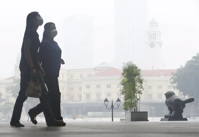 Office workers wearing masks walk during lunch hour at the central business district in Singapore September 29, 2015. (Photo by Edgar Su/Reuters)