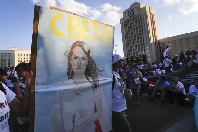 People carry a portrait of Sviatlana Tsikhanouskaya, former candidate for the presidential elections during opposition rally in front of the government building in Minsk, Belarus, Monday, August 17, 2020. Lukashenko's main challenger, Sviatlana Tsikhanouskaya, who fled on Tuesday to neighbouring Lithuania, posted a new video in which she disputed the results of the vote and demanded that the government start a dialogue with demonstrators. (Photo by Sergei Grits/AP Photo)