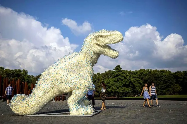 A dinosaur sculpture exhibited as part of the 9th Art Moments contemporary visual arts festival at a public square in Budapest, Hungary, Wednesday, September 14, 2016. The four-meter-tall installation was made by a group of young artists and university students based on the instructions of Hungarian sculptors Gergo Kovach and Gyorgy Szasz out of plastic and glass bottles bonded by spray foam insulation. (Photo by Balazs Mohai/MTI via AP Photo)