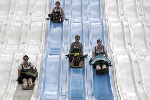 People enjoy a fun slide at the 183rd Oktoberfest beer festival in Munich, southern Germany, Tuesday, September 20, 2016. The world's largest beer festival will be held from Sept. 17 to Oct. 3, 2016. (Photo by Matthias Schrader/AP Photo)
