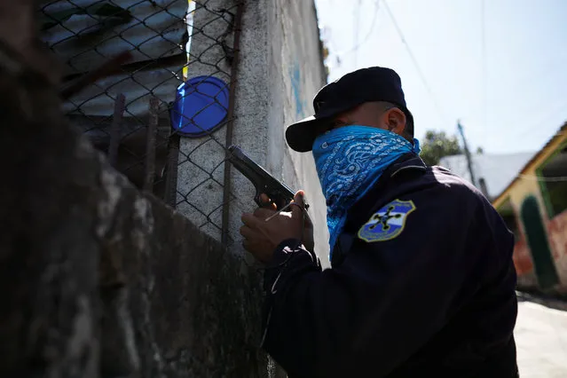 A Salvadoran policeman observes a search in a house in the area where according to local media, a policeman and two gang members were killed, in San Salvador, El Salvador, February 2, 2018. (Photo by Jose Cabezas/Reuters)