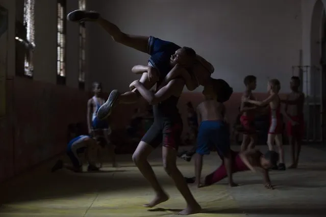 Children practice during a wrestling lesson in downtown Havana, October 23, 2014. Picture taken October 23, 2014. (Photo by Alexandre Meneghini/Reuters)