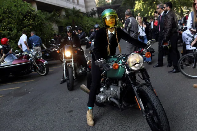 A woman rides a motorcycle during “The Distinguished Gentleman’s Ride” vintage motorcycles race, as part of a campaign to raise awareness on prostate cancer, in Santiago, Chile September 25, 2016. (Photo by Pablo Sanhueza/Reuters)
