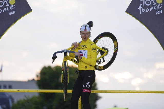 Tour de France winner Tadej Pogacar of Slovenia celebrates on the podium after the twenty-first stage of the Tour de France cycling race over 132.3 kilometers (82.1 miles) with start in Mantes-la-Ville and finish on the Champs-Elysees in Paris, France, Sunday, July 27, 2025. (Photo by Mosa'ab Elshamy/AP Photo)