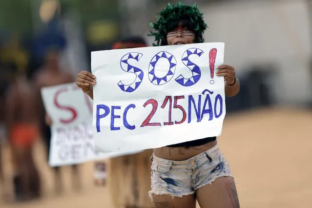 A indigenous woman protests at a sports arena during the first World Games for Indigenous Peoples in Palmas, Brazil, October 25, 2015. The sign says: "SOS! No to the proposed constitutional amendment 215 (PEC 215)". (Photo by Ueslei Marcelino/Reuters)