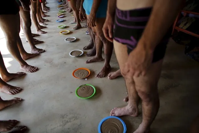 Prisoners stand by plates of clay before a therapy session as part of the ACUDA programme, at a complex of ten prisons in Porto Velho, Rondonia State, Brazil, August 28, 2015. According to ACUDA, prisoners can spend most of their hours in dank, dark cells and the clay therapy is designed to improve their skin. It is part of an alternative therapy programme the charity uses to address the physical and emotional needs of inmates. (Photo by Nacho Doce/Reuters)