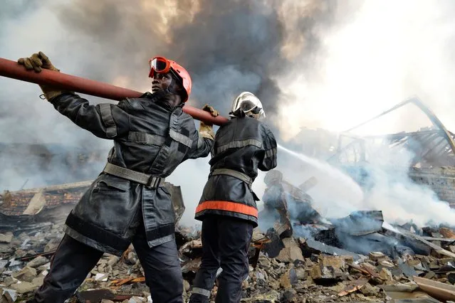 Firefighters battle the remnants of a fire at the Drocolor paint factory on December 6, 2017 in Abidjan. A huge fire ripped through a paint factory in the Ivorian capital on December 6, causing multiple explosions, and witnesses said several people were badly burnt. There was no immediate word on the tally of people caught in the blaze, which sent a thick column of smoke high above Abidjan's industrial zone, an AFP correspondent said. (Photo by Sia Kambou/AFP Photo)