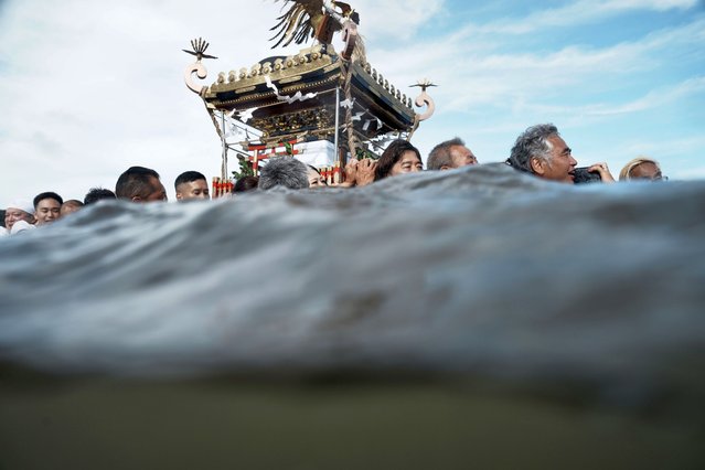 Participants carry a portable shrine, or mikoshi, into the sea during a purification rite at the annual Kurihama Sumiyoshi Shrine Festival in Kurihama, Yokosuka city, south of Tokyo, on Sunday, July 27, 2025. (Photo by Eugene Hoshiko/AP Photo)