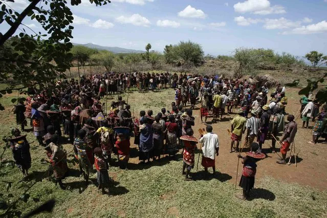 Pokot girls and adults stand in a circle during an initiation ceremony of over a hundred girls passing over into womanhood, about 80 km (50 miles) from the town of Marigat in Baringo County December 6, 2014. (Photo by Siegfried Modola/Reuters)