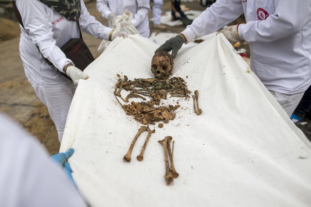 Volunteers carry the remains of unclaimed bodies after the remains were dug out from a graveyard during a mass exhumation at Poh Teck Tung Foundation Cemetery in Samut Sakhon province, Thailand November 3, 2015. (Photo by Athit Perawongmetha/Reuters)