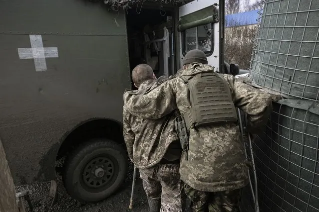 A medic from Ukraine's 72nd Mechanized Brigade helps an injured soldier into an evacuation ambulance at a stabilization hospital near the frontline on February 22, 2023 in the Donbas region of eastern Ukraine. Heavy fighting continues in Donbas, as Russian forces press a winter offensive ahead of February 24, which marks a year since the invasion of Ukraine. (Photo by John Moore/Getty Images)