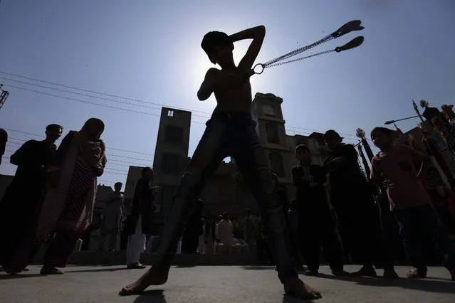 A Pakistani Shiite Muslim boy is silhouetted against the sky as he flagellates himself with chains and blades a day ahead of  the commemoration of Ashura, in Peshawar, Pakistan, 11 October 2016. (Photo by Bilawal Arbab/EPA)