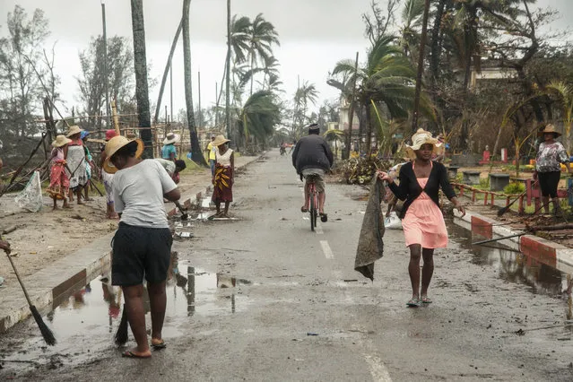 People employed by the FID (Fonds d'Intervention pour le Développement) clean up after the passage of cyclone Batsirai, in the Tanambao district on February 8, 2022 in Mananjary. The death toll from Tropical Cyclone Batsirai has risen to 92 in Madagascar, authorities said Wednesday, as humanitarian organisations ramped up aid efforts with more than 110,000 people in need of emergency assistance. (Photo by Rijasolo/AFP Photo)