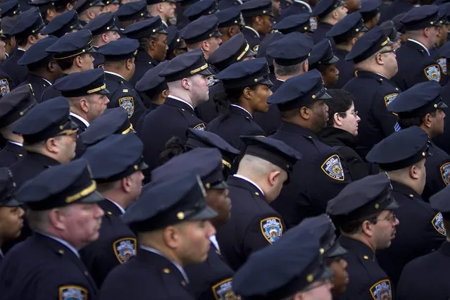 Police officers from the 84th Precinct listen during the funeral for slain New York Police Department officer Wenjian Liu in the Brooklyn borough of New York January 4, 2015. (Photo by Carlo Allegri/Reuters)