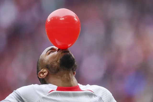 Leipzig's Christopher Nkunku inflates a balloon as he celebrates after scoring the opening goal during the German Bundesliga soccer match between RB Leipzig and TSG 1899 Hoffenheim in Leipzig, Germany, Saturday, April 29, 2023.(Photo by Jan Woitas/dpa via AP Photo)