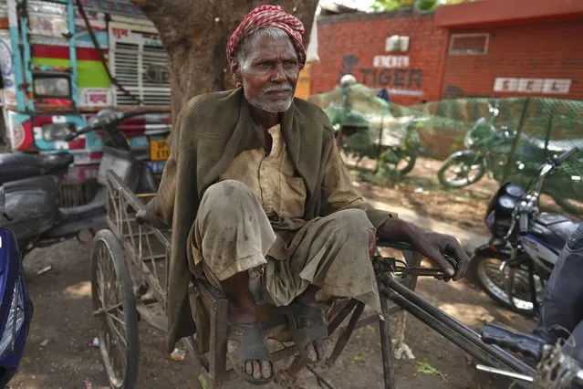 An elderly daily wage laborer takes a break at work on May Day in Prayagraj, India, Monday, May 1, 2023. (Photo by Rajesh Kumar Singh/AP Photo)