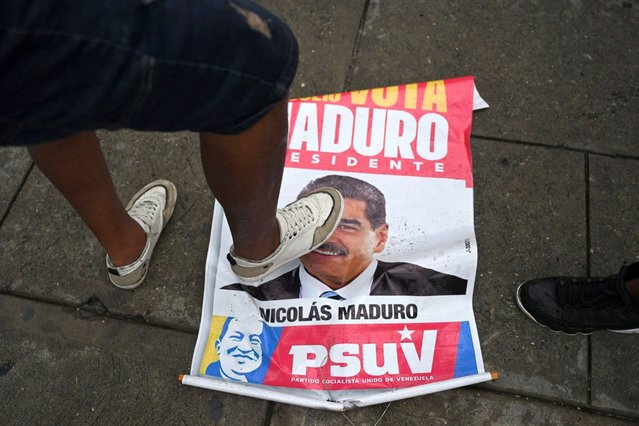 An opponent of Venezuelan President Nicolas Maduro's government steps on an election campaign poster with the image of Maduro during a protest at the Petare neighborhood in Caracas on July 29, 2024, a day after the Venezuelan presidential election. President Nicolas Maduro was declared the winner of Venezuela's presidential election but the opposition and key regional neighbours immediately rejected the official results. (Photo by Raul Arboleda/AFP Photo)