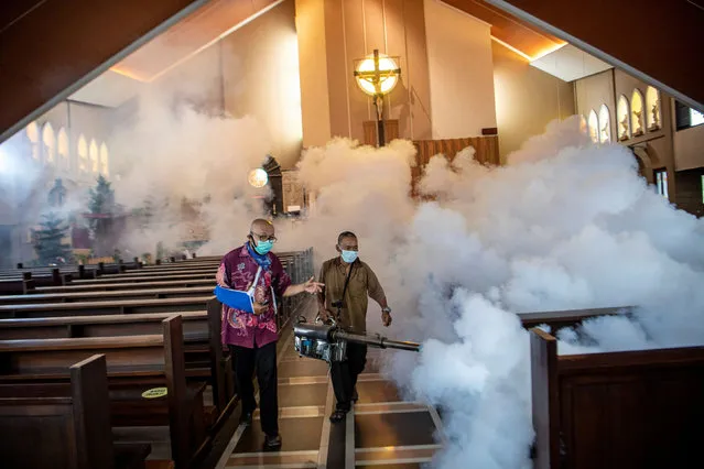 People disinfect a church ahead of Christmas mass in Palembang, Indonesia on December 24, 2020. (Photo by Antara Foto via Reuters)