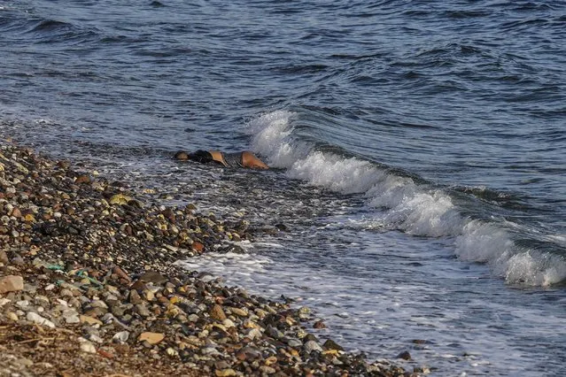 The body of an unidentified man is seen washed up on a beach on the Greek island of Lesbos. on Tuesday, March 1, 2022. Greece’s coast guard says six bodies have been recovered from the shore of the eastern island of Lesbos, and authorities suspect the people were migrants who died in their attempt to make it to Greece from the nearby Turkish coast. (Photo by Panagiotis Balaskas/AP Photo)