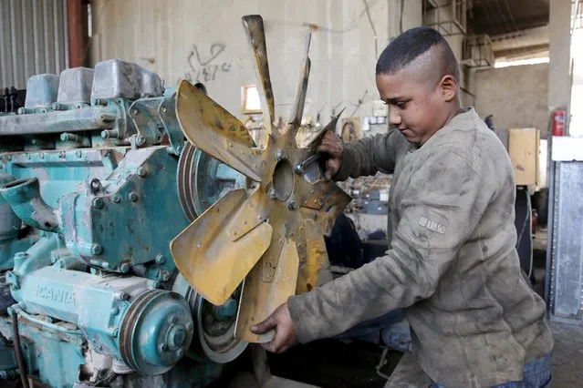 13-year-old Akram Karim works at generator repair workshop in Baghdad, November 16, 2015. (Photo by Khalid al-Mousily/Reuters)