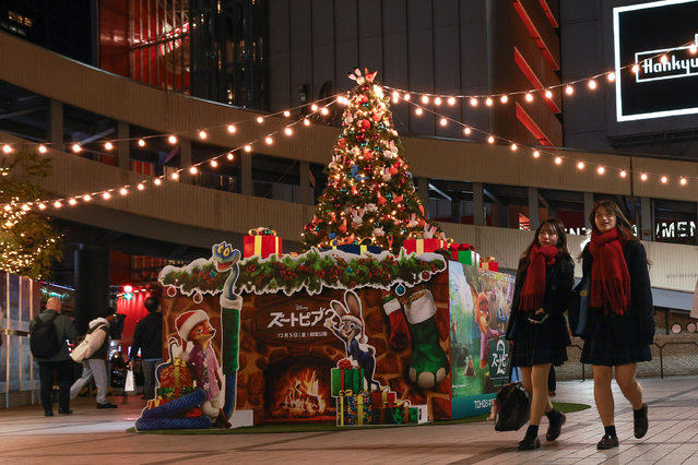 Shoppers walk past a Christmas tree during the Christmas shopping season on December 18, 2025 in Osaka, Japan. (Photo by Buddhika Weerasinghe/Getty Images)