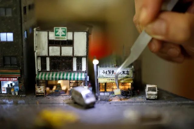Taiwanese artist Hank Cheng poses with his miniature model of street scenes, in New Taipei City, Taiwan on June 17, 2018. Cheng's first miniature model, created over three years ago, was based on a restaurant he used to visit while studying in Japan. (Photo by Tyrone Siu/Reuters)