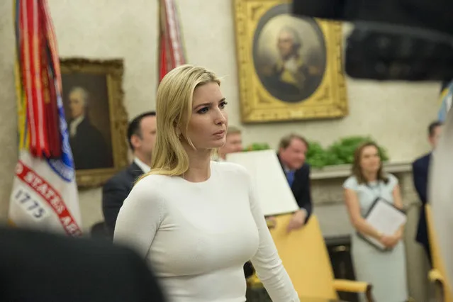 Ivanka Trump, the daughter and assistant to President Donald Trump, center, watches as he father addresses members of the media after he signed an executive order to end family separations at the border, during an event in the Oval Office of the White House in Washington, Wednesday, June 20, 2018. (Photo by Pablo Martinez Monsivais/AP Photo)