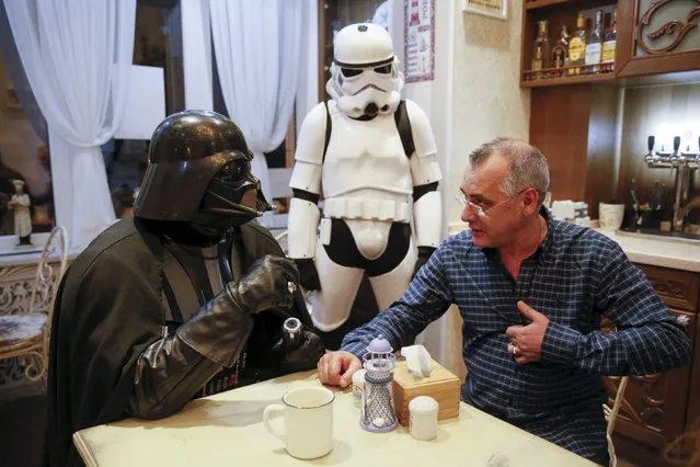 Darth Mykolaiovych Vader (L), who is dressed as the Star Wars character Darth Vader, poses for a picture as he speaks with a supporter in a cafe in Odessa, Ukraine, December 3, 2015. Darth Vader was bent on galactic domination, but his Ukrainian namesake enjoys more mundane pursuits: local politics, walking the family dog and a spot of embroidery. (Photo by Valentyn Ogirenko/Reuters)