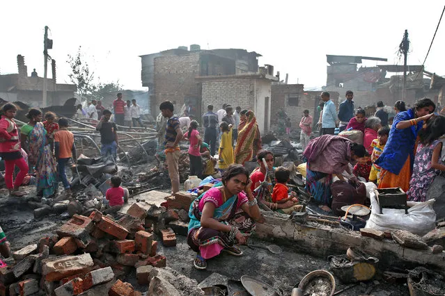 A woman squats amongst the rubble of her home after a fire in a slum area left hundreds homeless in the old quarters of Delhi, India, November 8, 2016. (Photo by Cathal McNaughton/Reuters)