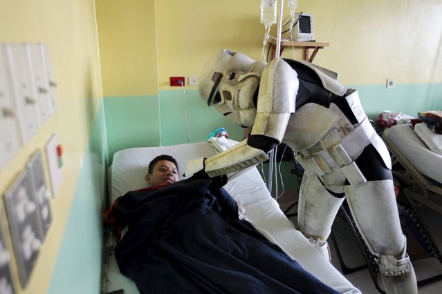 A cosplayer dressed as a Storm Trooper from the Star Wars movie series interacts with a child during a charity event organised by the El Salvador Star Wars fan club at the Benjamin Bloom National Children's Hospital in San Salvador, El Salvador December 14, 2015. (Photo by Jose Cabezas/Reuters)
