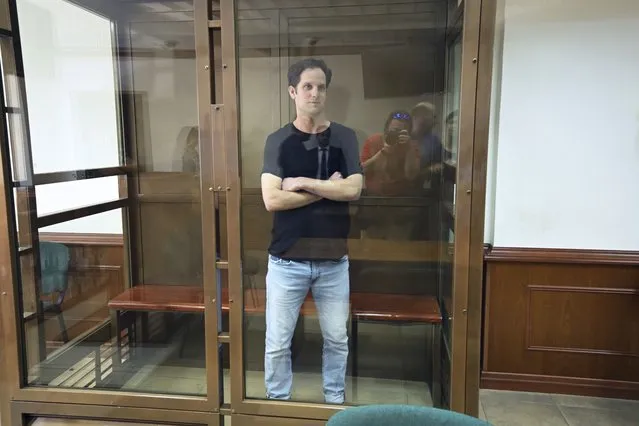Wall Street Journal reporter Evan Gershkovich stands in a glass cage in a courtroom at the Moscow City Court in Moscow, Russia, Thursday, June 22, 2023. Gershkovich, a Wall Street Journal reporter detained on espionage charges in Russia, appeared in court Thursday to appeal his extended detention. (Photo by Dmitry Serebryakov/AP Photo)