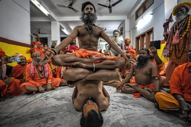 Hindu holy men display their yoga skills before media on International Day of Yoga at the Kamakhya temple in Guwahati, Assam, India, Wednesday, June 21, 2023. The holy men from different parts of this northeastern state arrived at the temple to attend the Ambubachi festival that starts on Thursday. (Photo by Anupam Nath/AP Photo)