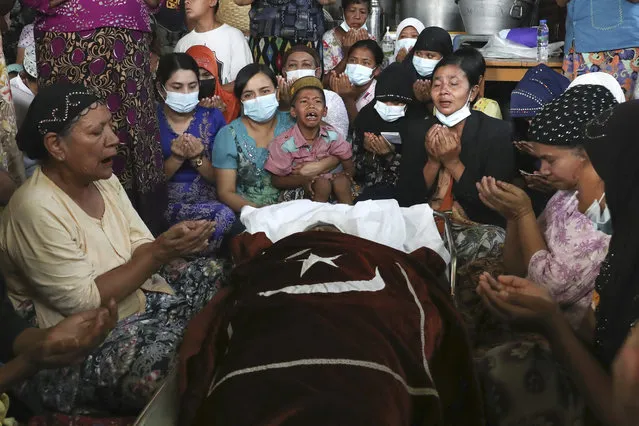 Family and relatives pray next to the body of the Muslim woman who her family said was killed by the army Sunday, during her funeral service in Mandalay, Myanmar, Monday, March 1, 2021. Defiant crowds returned to the streets of Myanmar's biggest city of Yangon on Monday, determined to continue their protests against the military's seizure of power a month ago, despite security forces having killed at least 18 people around the country just a day earlier. (Photo by AP Photo/Stringer)
